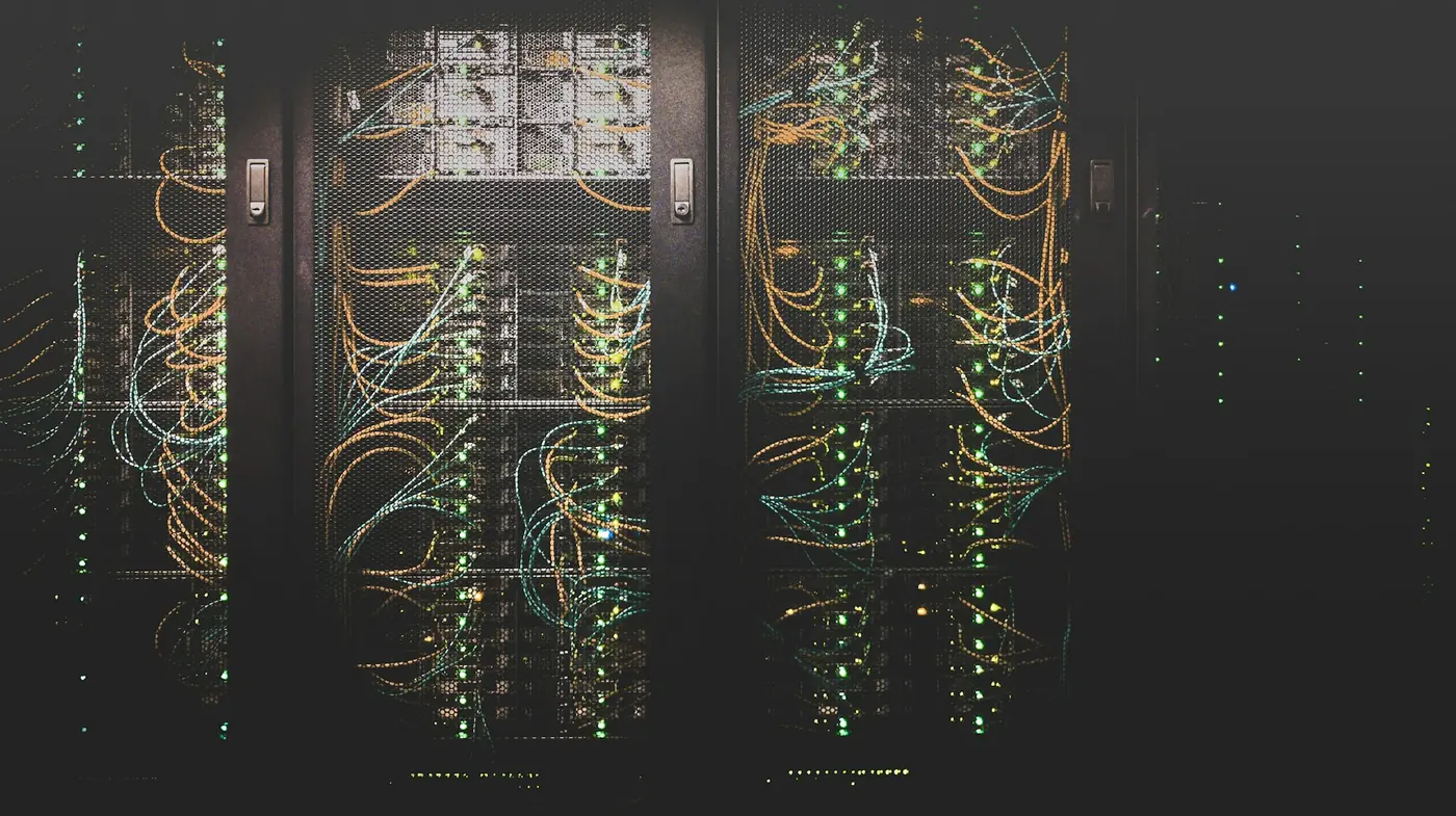 Armadi rack in un datacenter buio con cavi colorati e piccole luci
