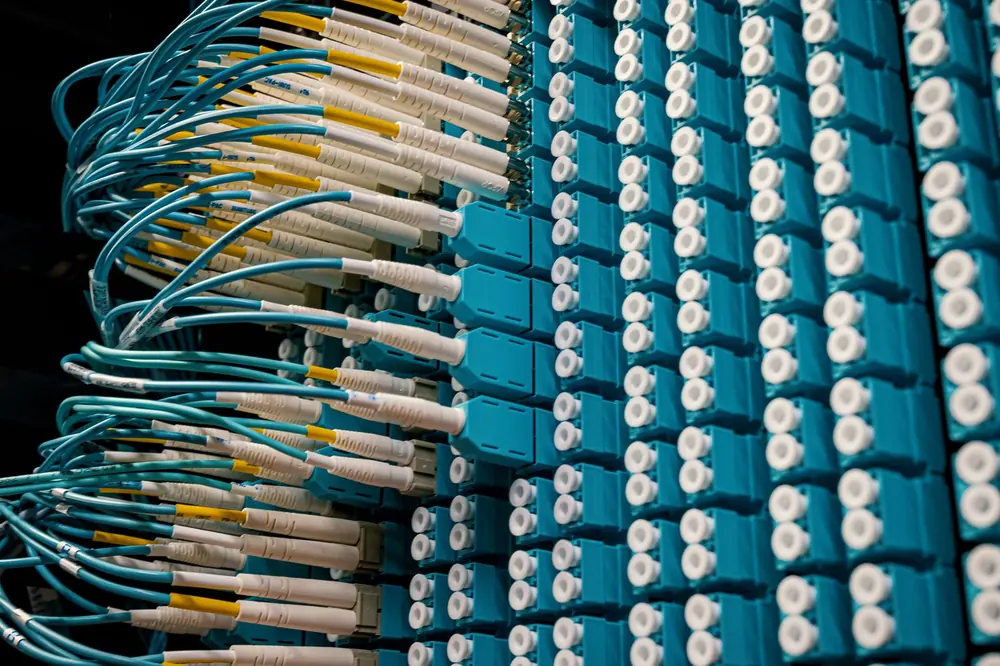 Cavi in fibra ottica collegati a un pannello di connessioni in un datacenter