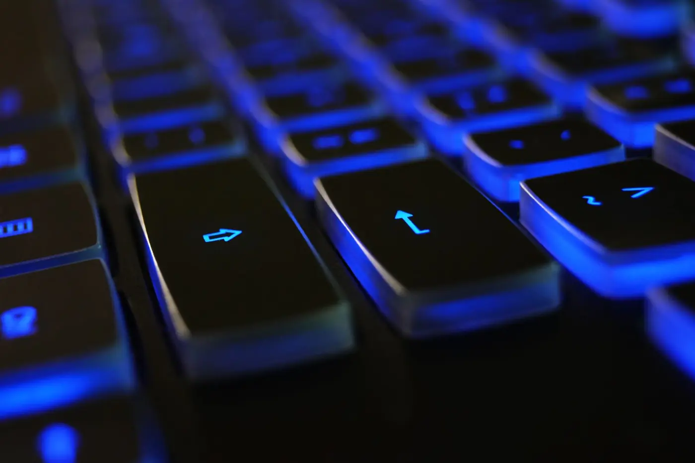 Primo piano di una tastiera nera con retroilluminazione blu