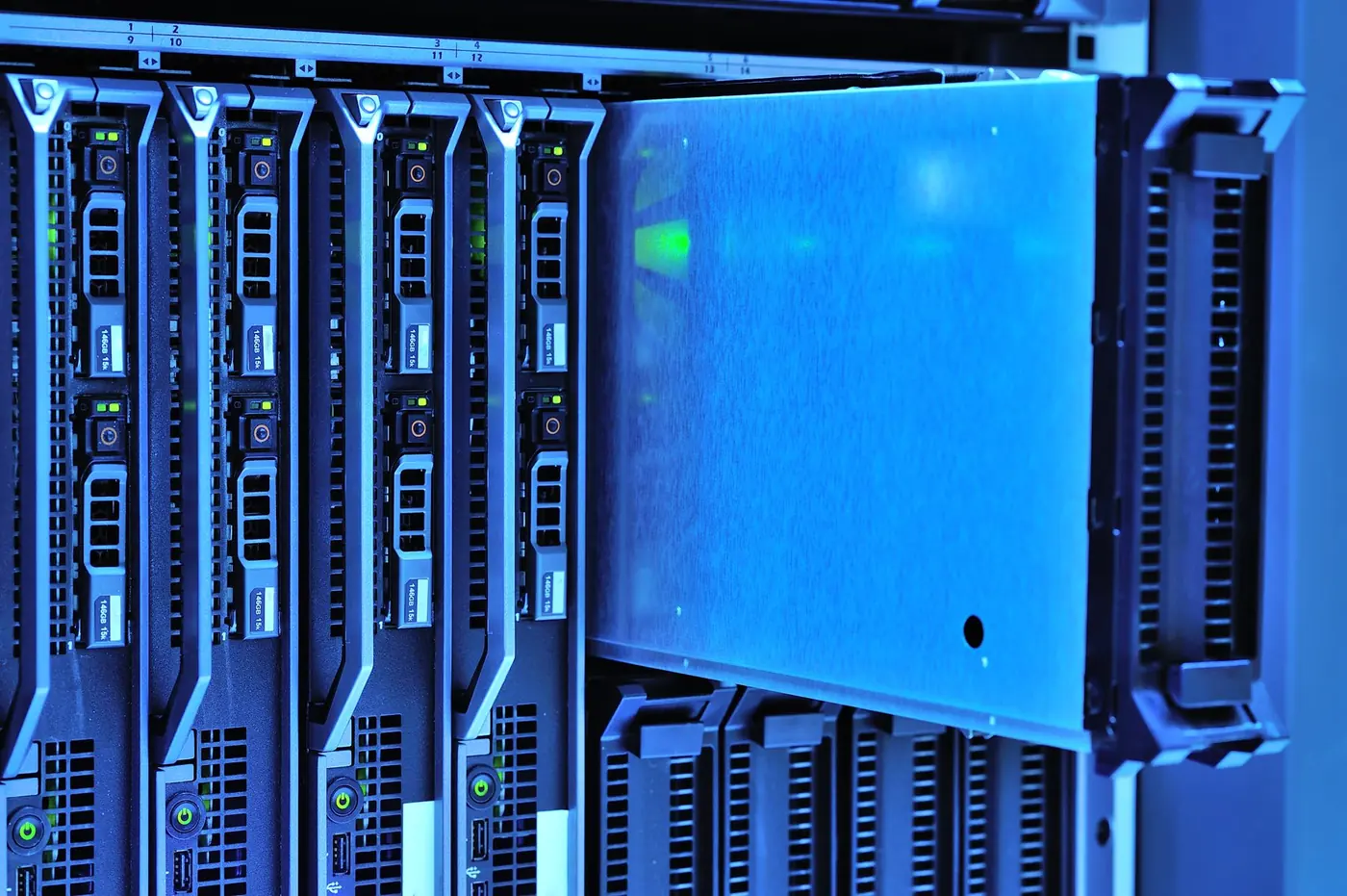 Moduli server e unita disco in un rack con illuminazione blu.
