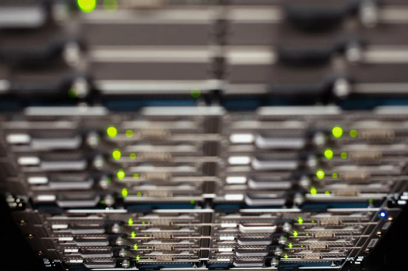 Vista dal basso di apparati di rete in un rack con LED verdi accesi in un data center.