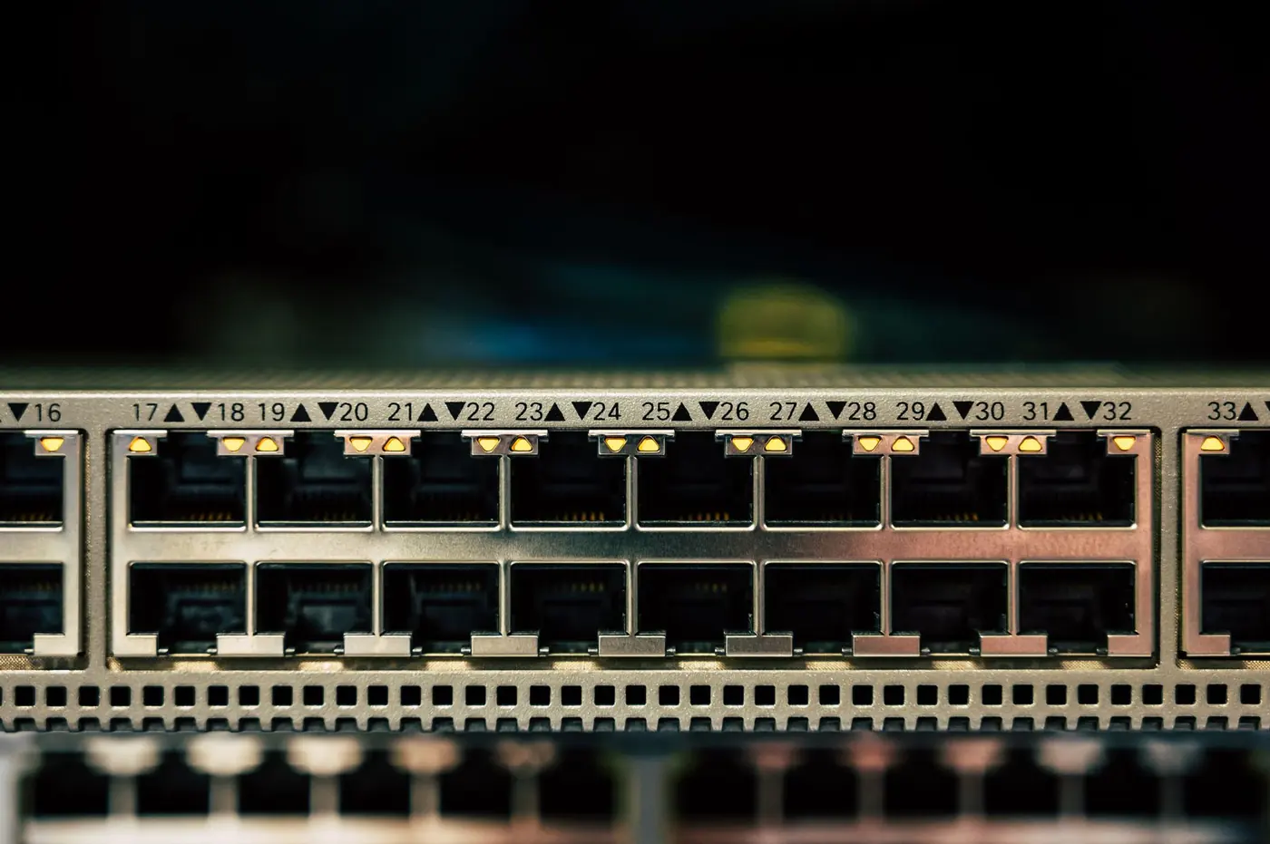 Porte Ethernet di uno switch in primo piano su fondo scuro.